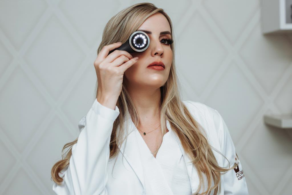 Dra. Vanessa Viríssimo Maciel realizando avaliação dermatológica com dermatoscópio