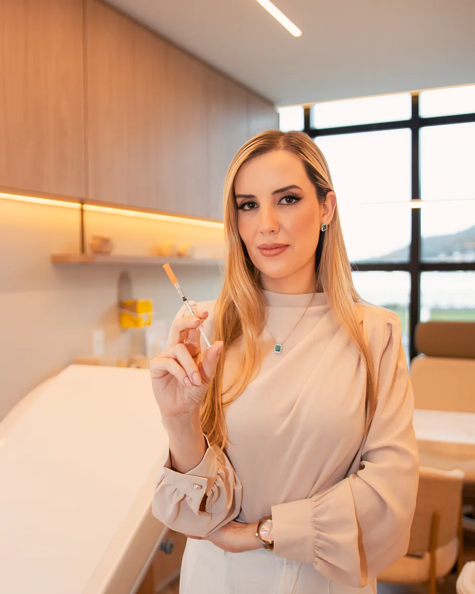 Dra. Vanessa Viríssimo Maciel em seu consultório, preparando a aplicação de um tratamento dermatológico